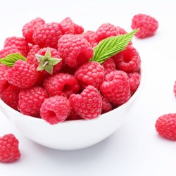 Crockery with  beautiful tempting raspberries Isolated on white background.